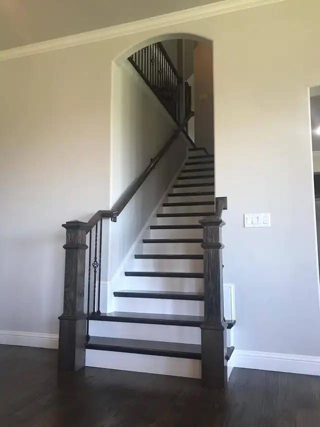 Long straight staircase with box newel posts at an arched entry