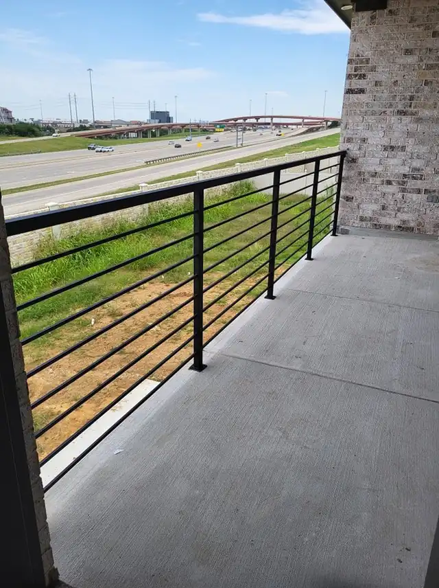 Black horizontal-bar metal railing along a concrete balcony