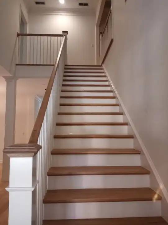 Long staircase with white risers and a white newel post