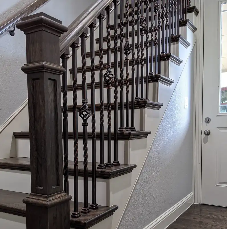 Dark stained box newel post with twisted and basket wrought-iron balusters